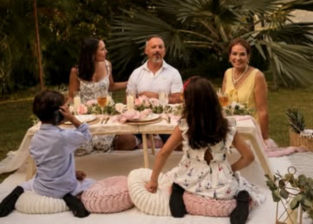 A family enjoying a styled picnic together in a tropical garden.